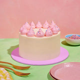 Classic Vanilla Cake by Crumbs & Doilies with pink piped buttercream and rainbow sprinkles on pastel background.